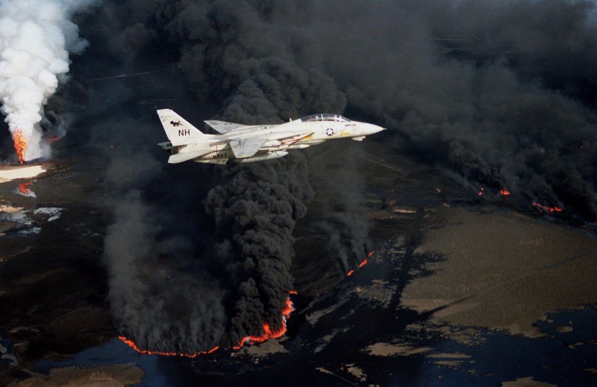 American F-14 flies over burning oil wells